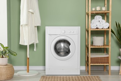 Photo of Stylish laundry room with washing machine. Interior design