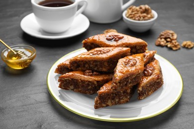 Photo of Delicious sweet baklava with walnuts on black table