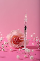 Cosmetology. Medical syringe, rose and gypsophila flowers on pink background