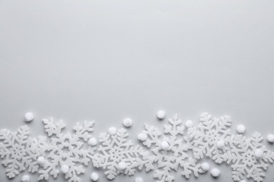 Beautiful snowflakes and decorative balls on white background, flat lay. Space for text