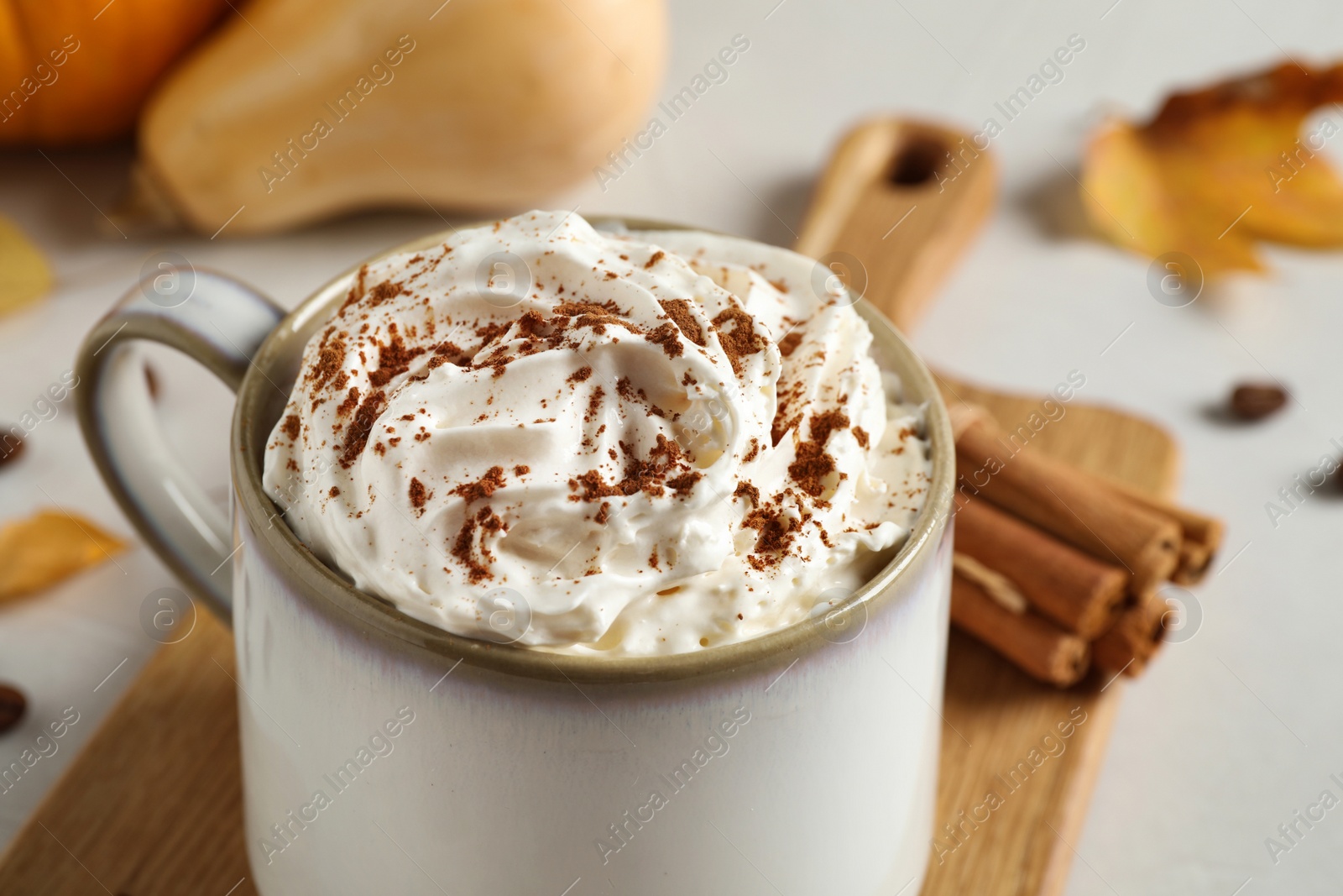Photo of Cup with tasty pumpkin spice latte on light table, closeup