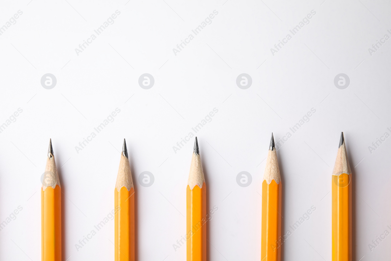 Photo of Graphite pencils on white background, top view. Space for text