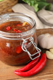 Photo of Tasty rhubarb sauce and ingredients on wooden table, closeup