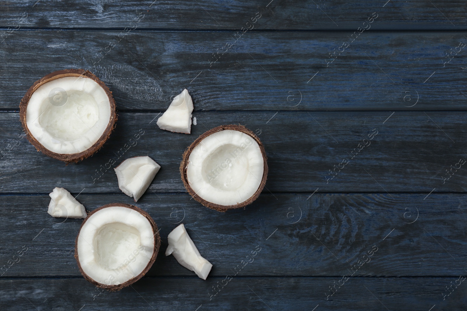 Photo of Flat lay composition with coconuts on dark wooden table, space for text. Cooking ingredients