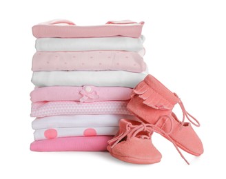 Photo of Stack of clean girl's clothes and booties on white background