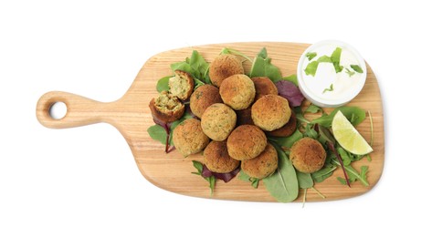 Photo of Delicious falafel balls with herbs, lime and sauce on white background, top view