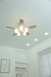 Ceiling fan with lamps indoors, low angle view