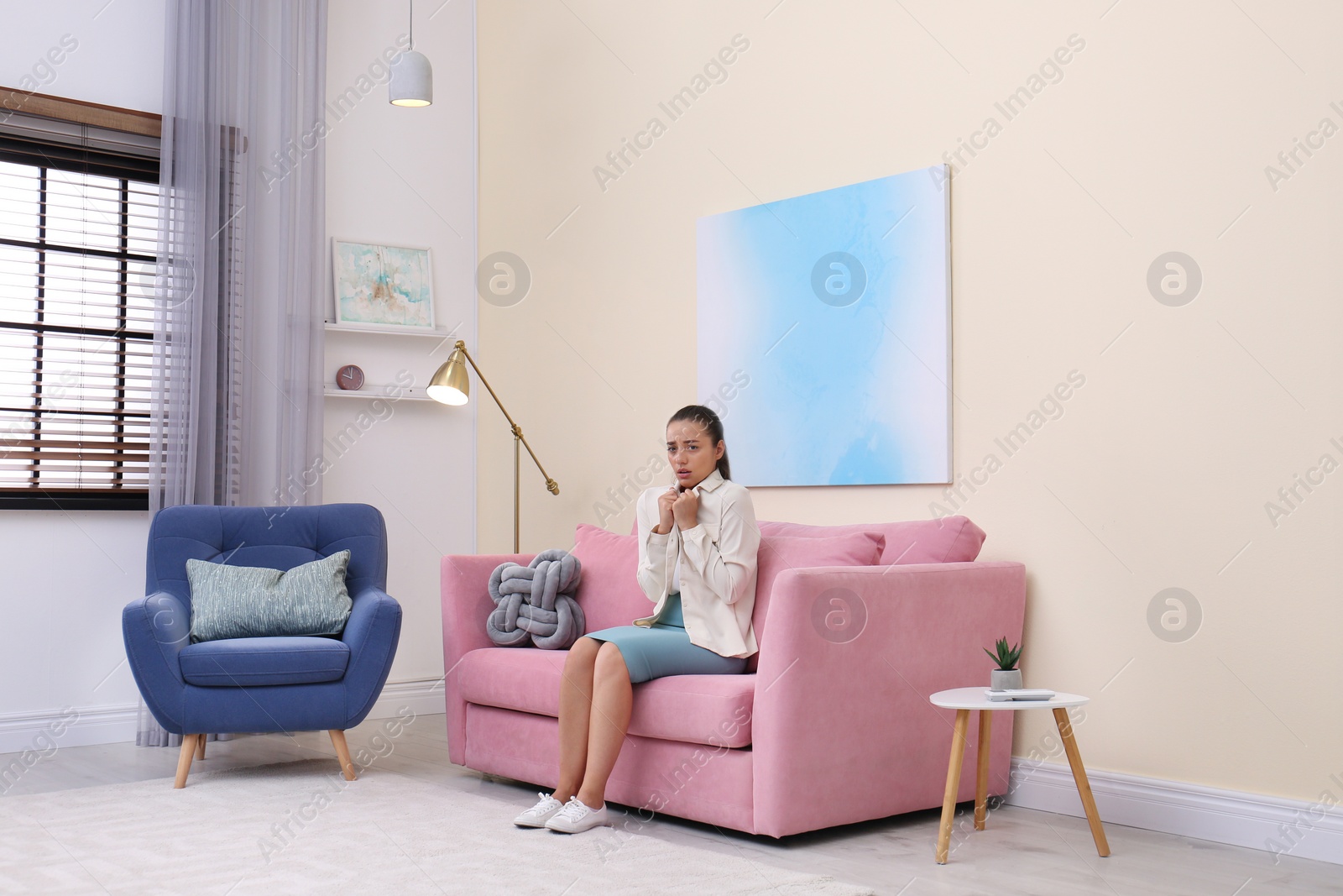 Photo of Young woman  suffering from cold under air conditioner at home