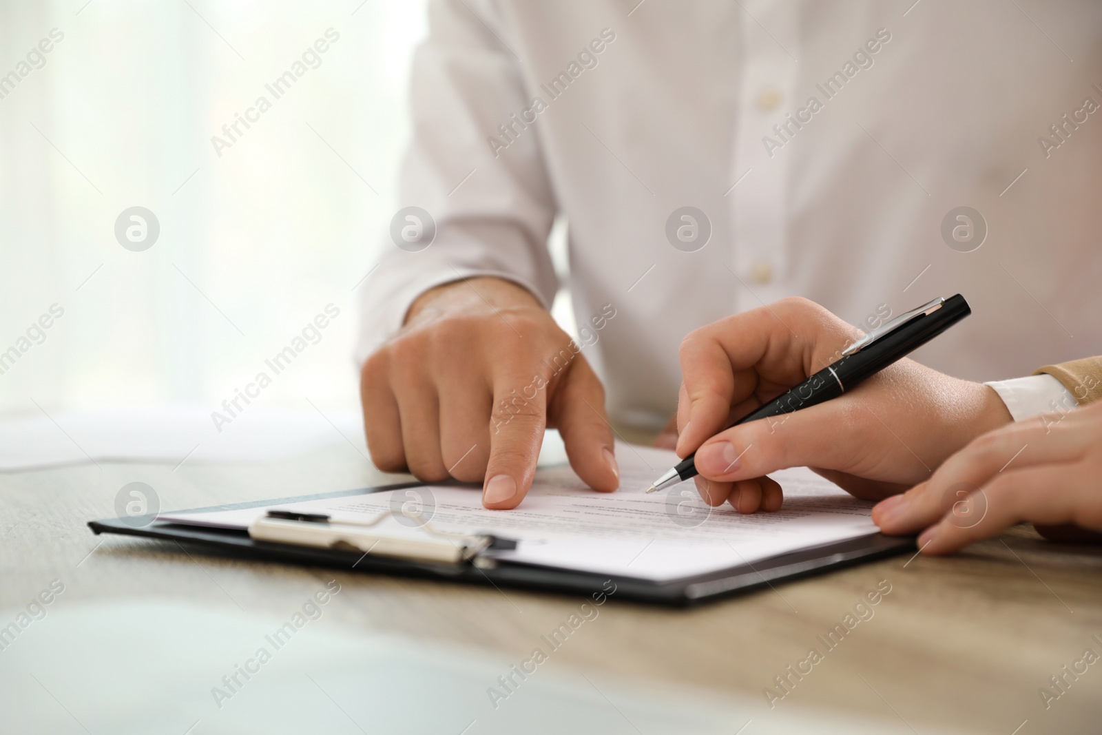 Photo of Businesspeople working with document at table indoors, closeup