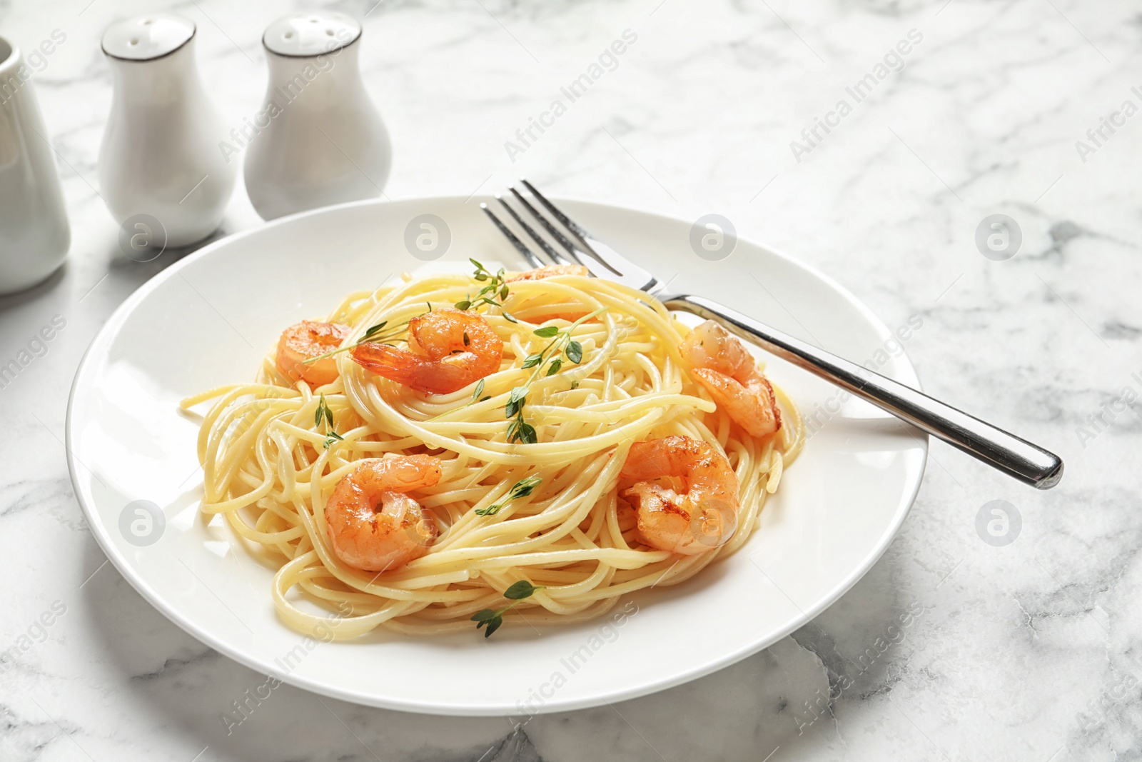 Photo of Plate with spaghetti and shrimps on table