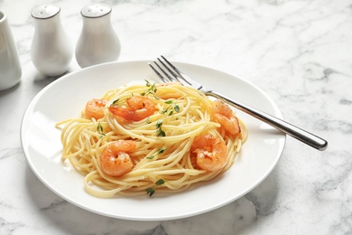 Photo of Plate with spaghetti and shrimps on table