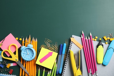 Flat lay composition with different school stationery on chalkboard surface