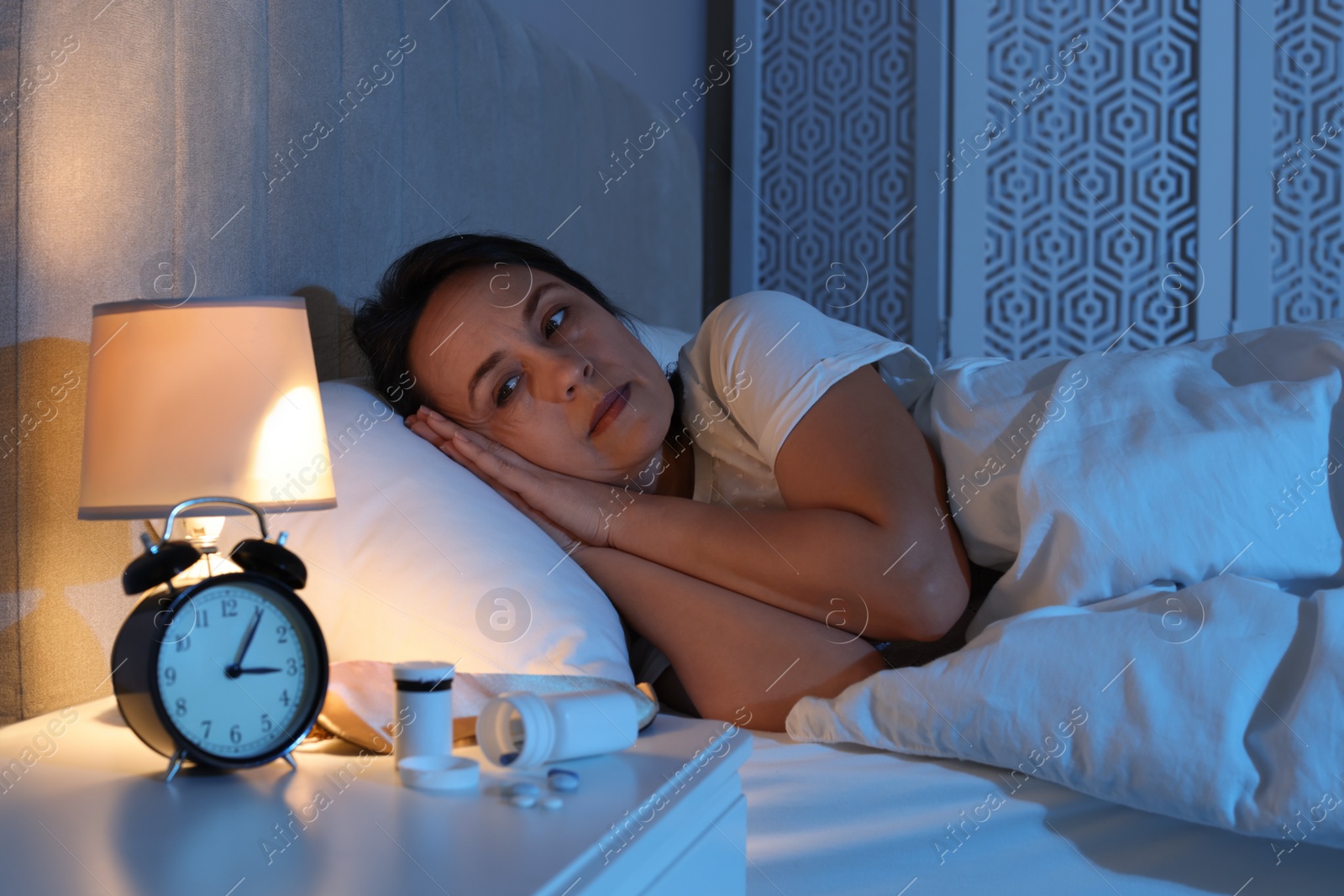 Photo of Mature woman suffering from insomnia in bed at night