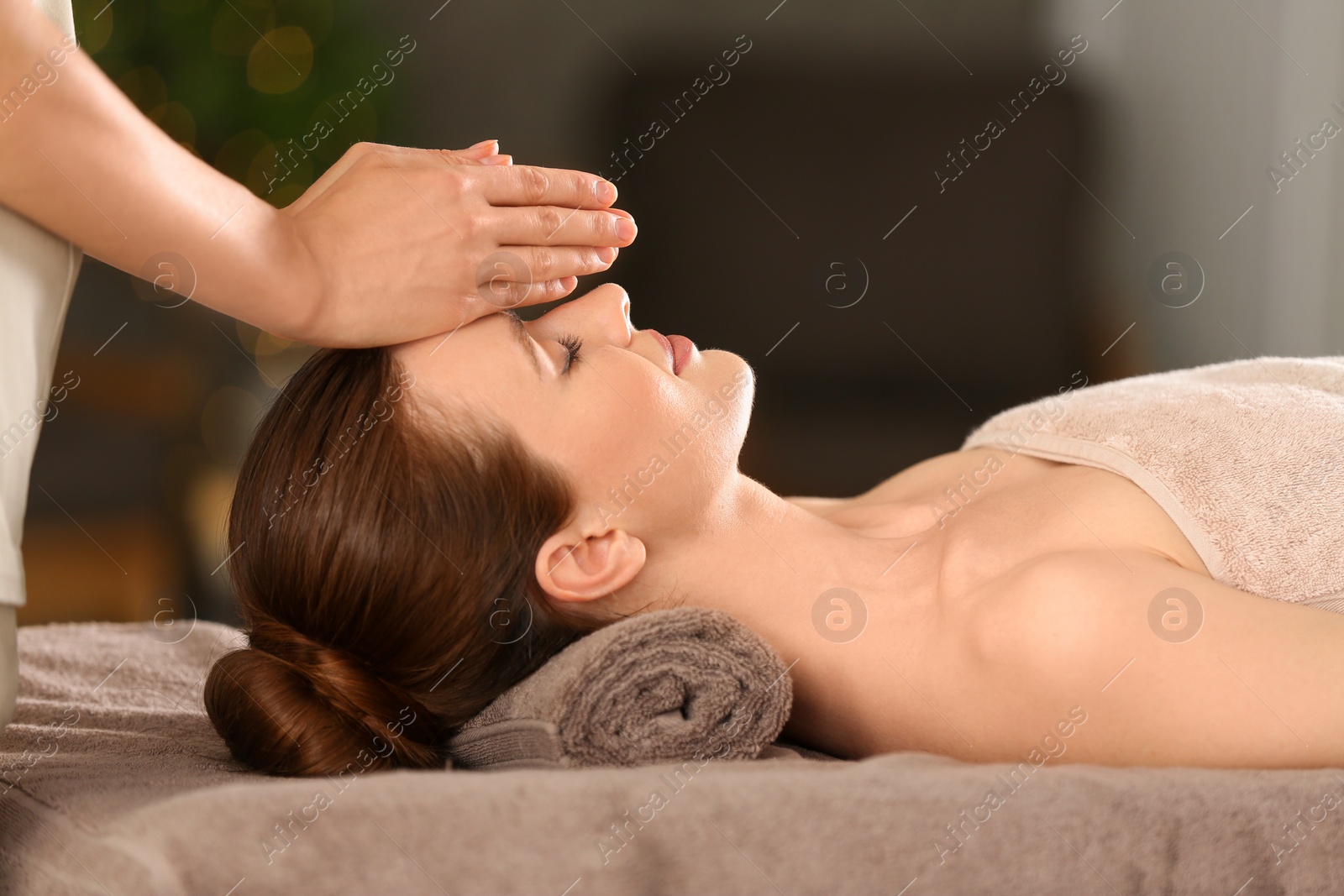 Photo of Beautiful young woman enjoying massage in spa salon