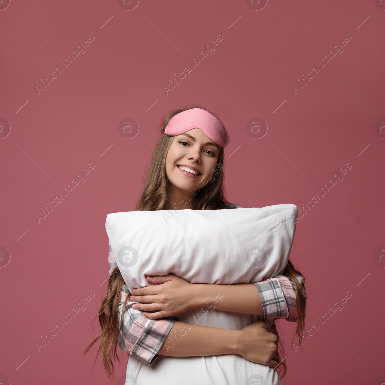 Photo of Beautiful woman with pillow on dusty rose background. Bedtime