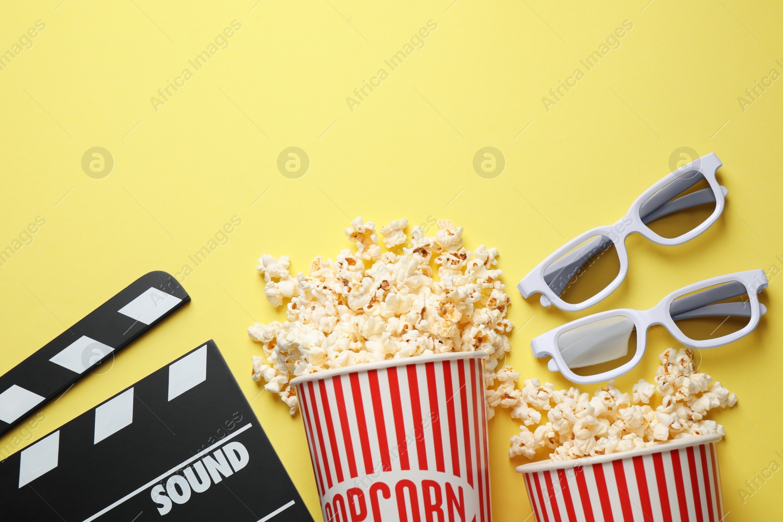 Photo of Flat lay composition with delicious popcorn on yellow background. Space for text