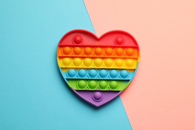 Photo of Heart shaped rainbow pop it fidget toy on color background, top view