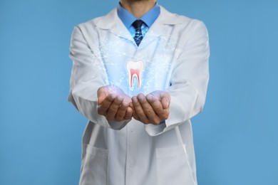 Image of Dentist showing virtual model of tooth on light blue background, closeup