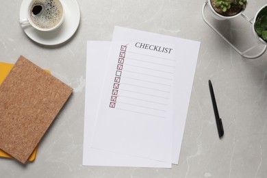 Paper sheet with inscription Checklist, cup of coffee and plants on light grey table, flat lay