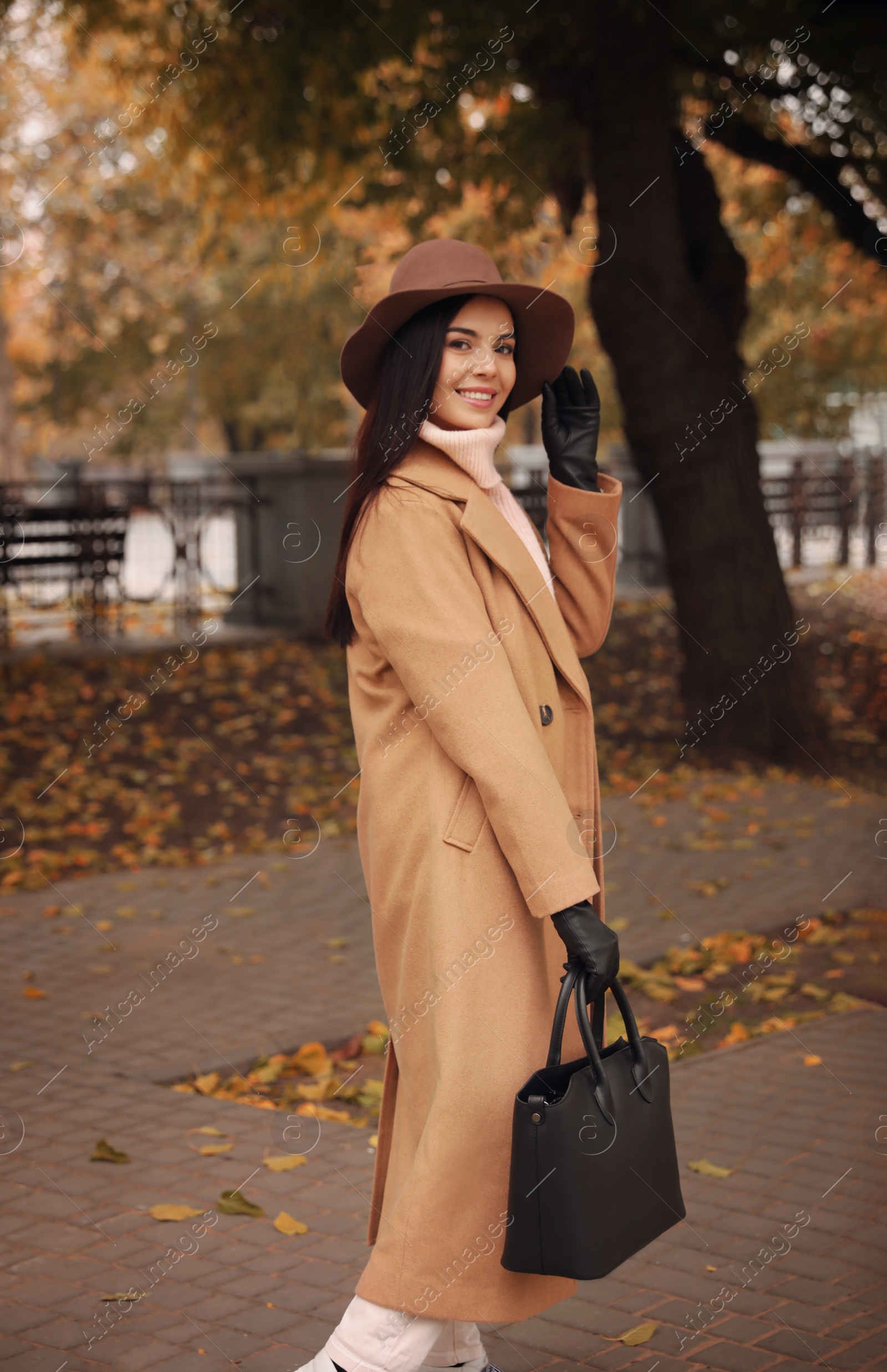 Photo of Young woman wearing stylish clothes in autumn park