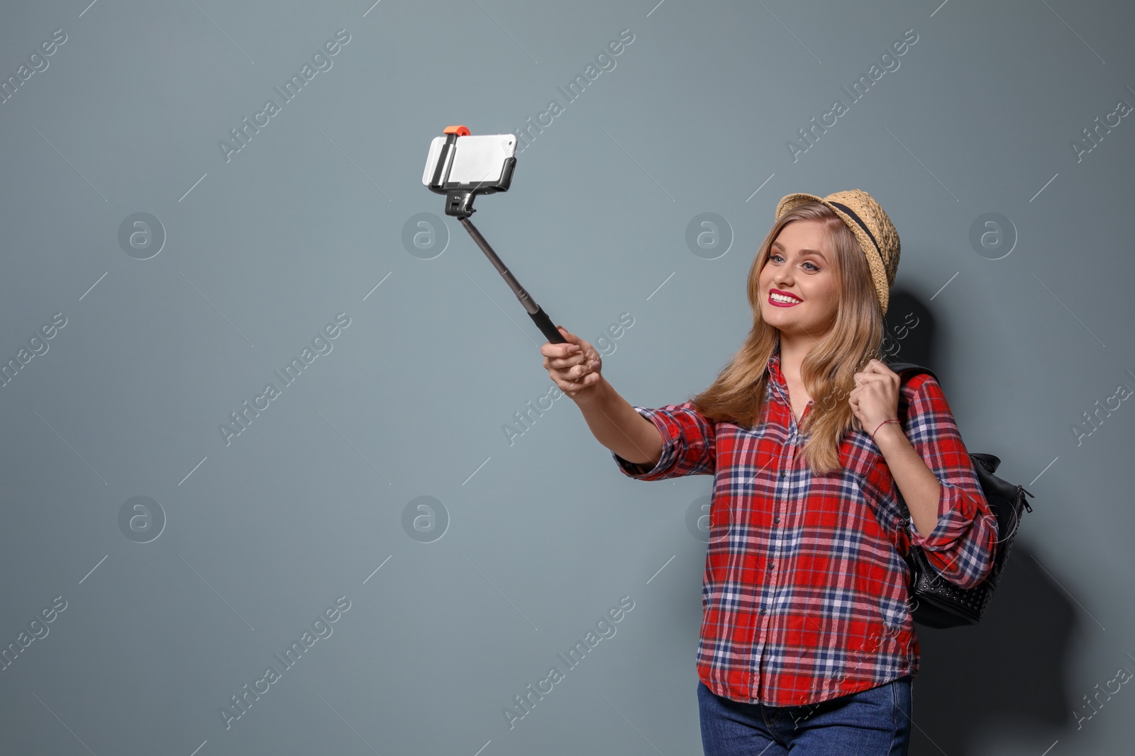 Photo of Attractive young woman taking selfie on color background