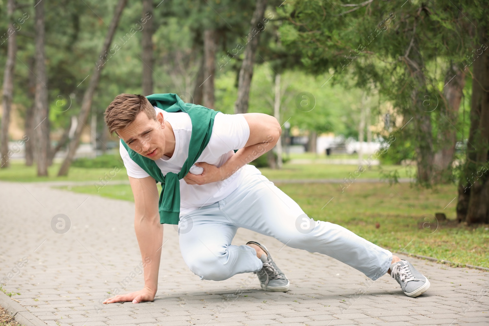 Photo of Young man having chest pain outdoors. Heart attack