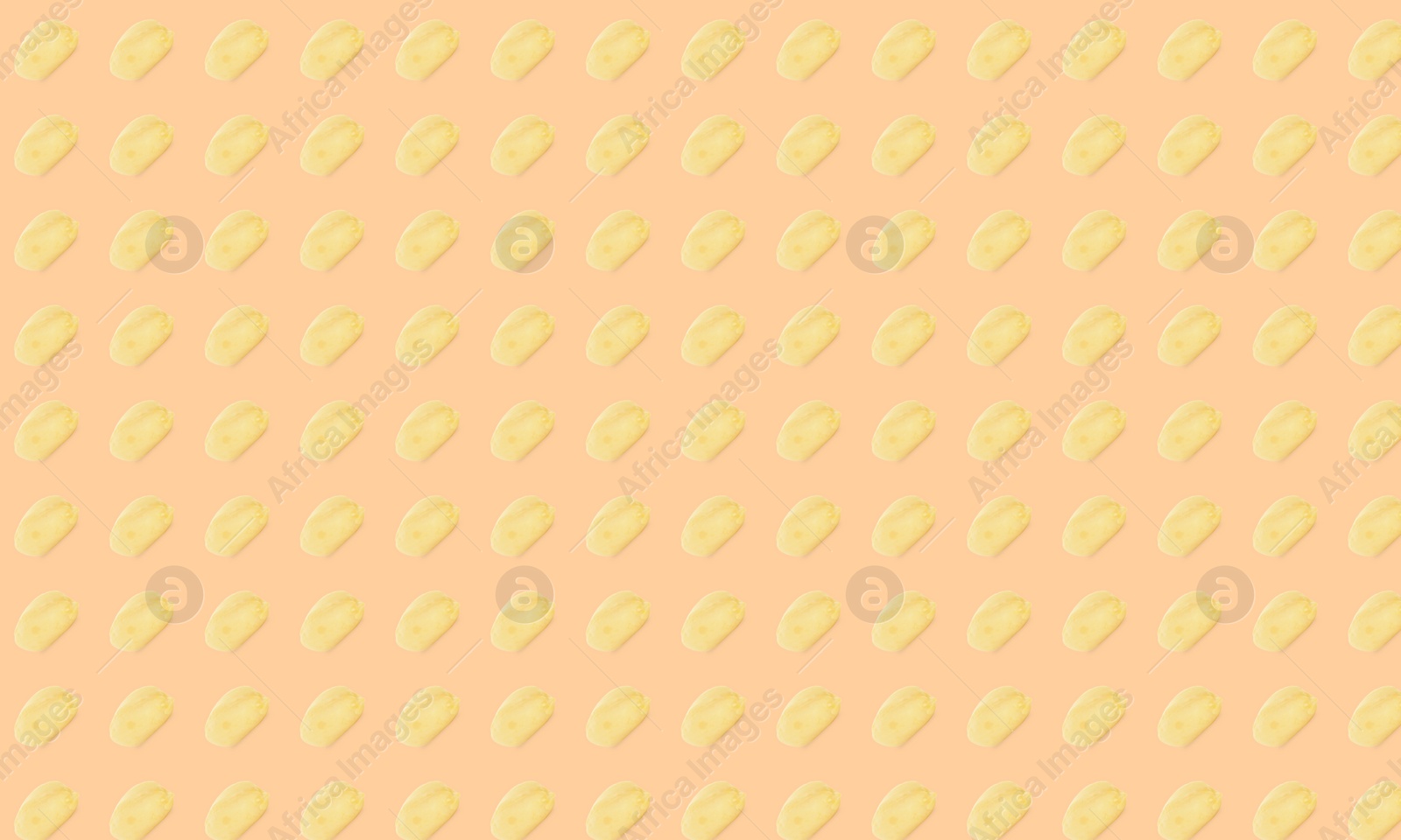 Image of Pattern of peeled peanuts on beige background