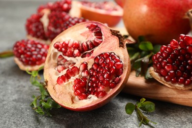 Delicious ripe pomegranates on grey table, closeup