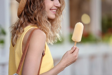 Photo of Happy young woman with delicious ice cream outdoors, closeup