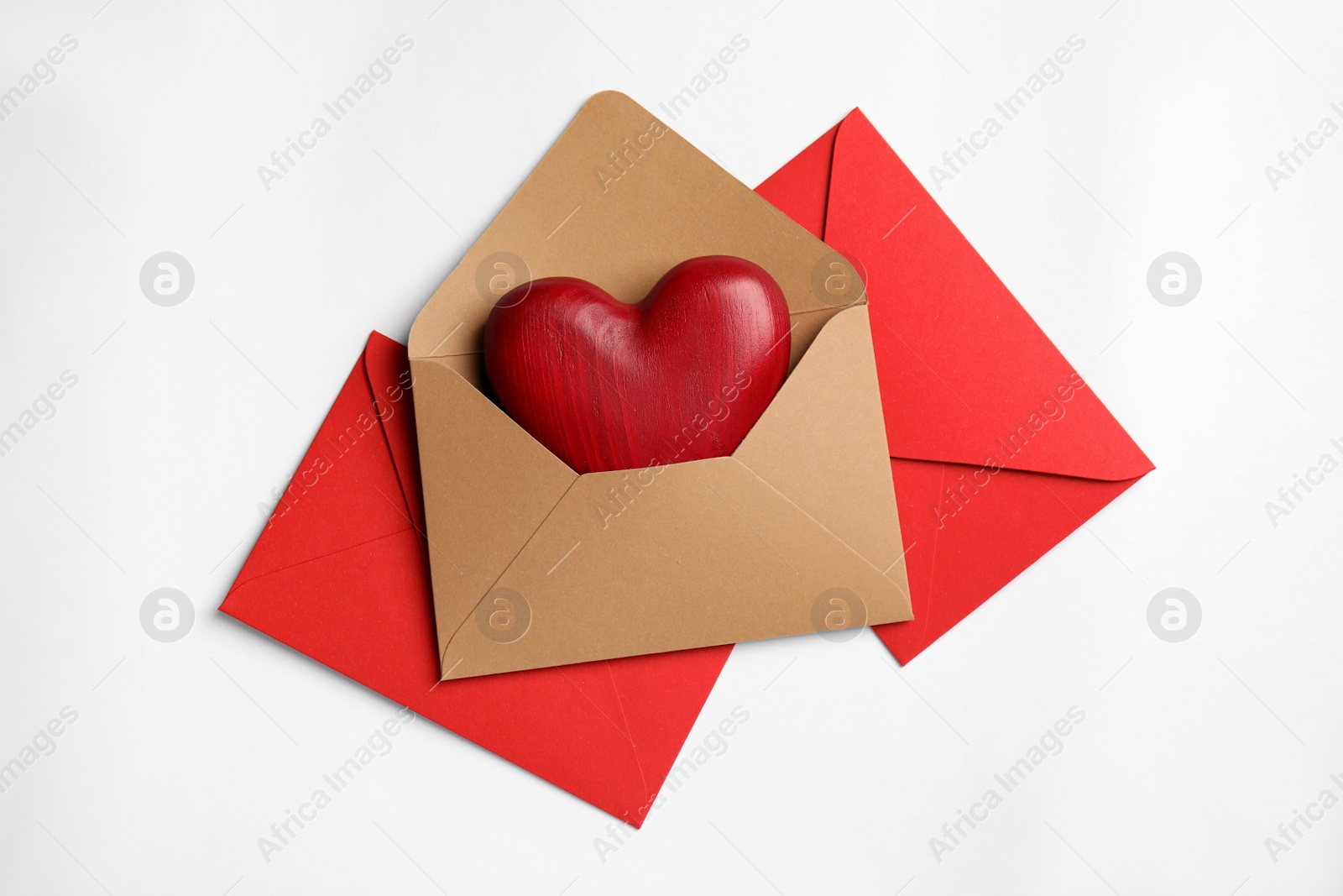 Photo of Decorative heart in envelope on white background, flat lay. Love letters