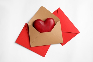 Photo of Decorative heart in envelope on white background, flat lay. Love letters