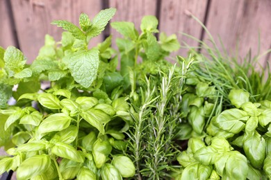 Photo of Different aromatic herbs on wooden background, closeup