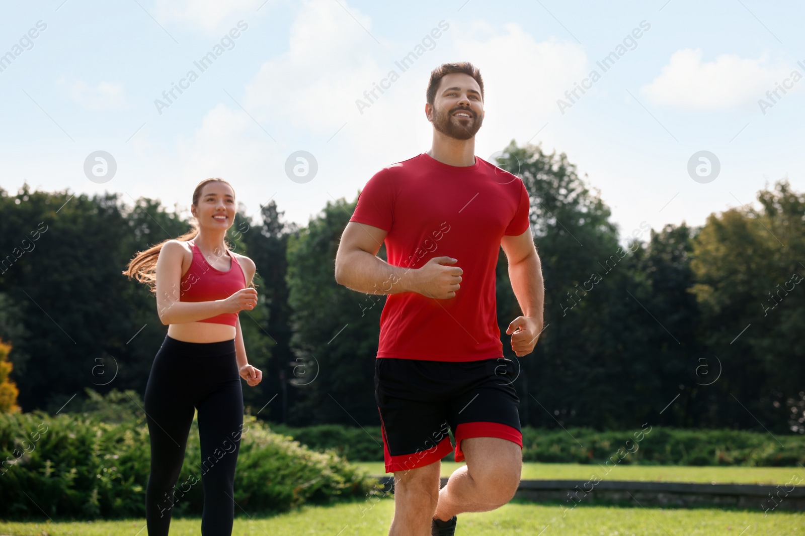 Photo of Healthy lifestyle. Happy couple running outdoors on sunny day, low angle view
