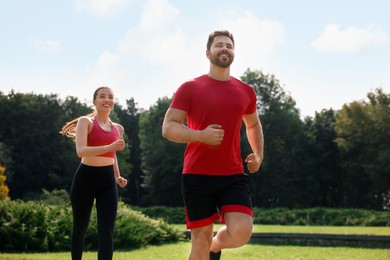 Healthy lifestyle. Happy couple running outdoors on sunny day, low angle view