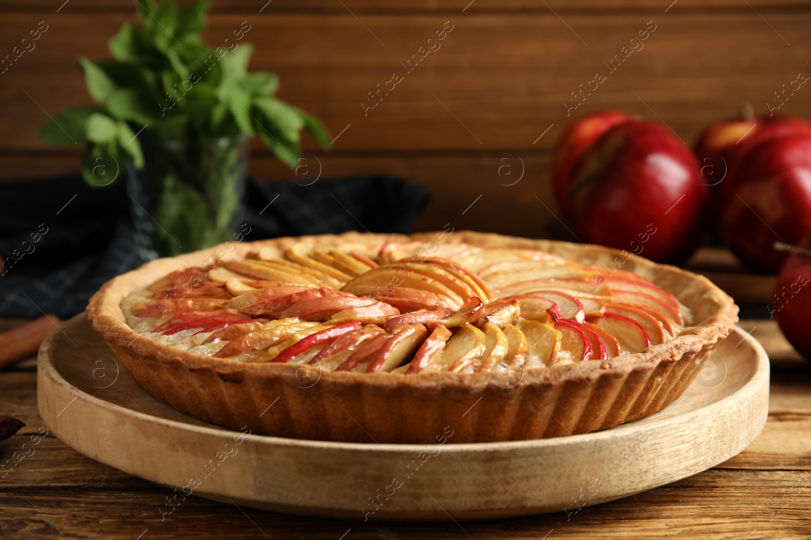 Photo of Delicious homemade apple tart on wooden table