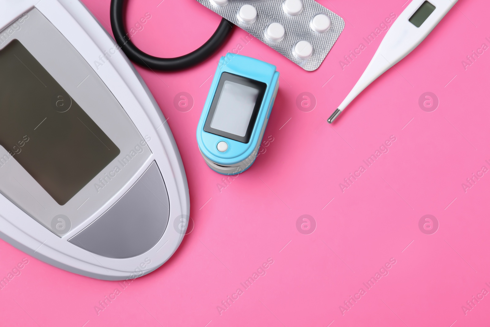 Photo of Digital pressure meter and medical objects on color background, top view. Space for text