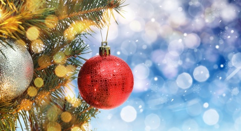 Image of Beautiful bauble hanging on Christmas tree against blurred lights, closeup view with space for text. Banner design