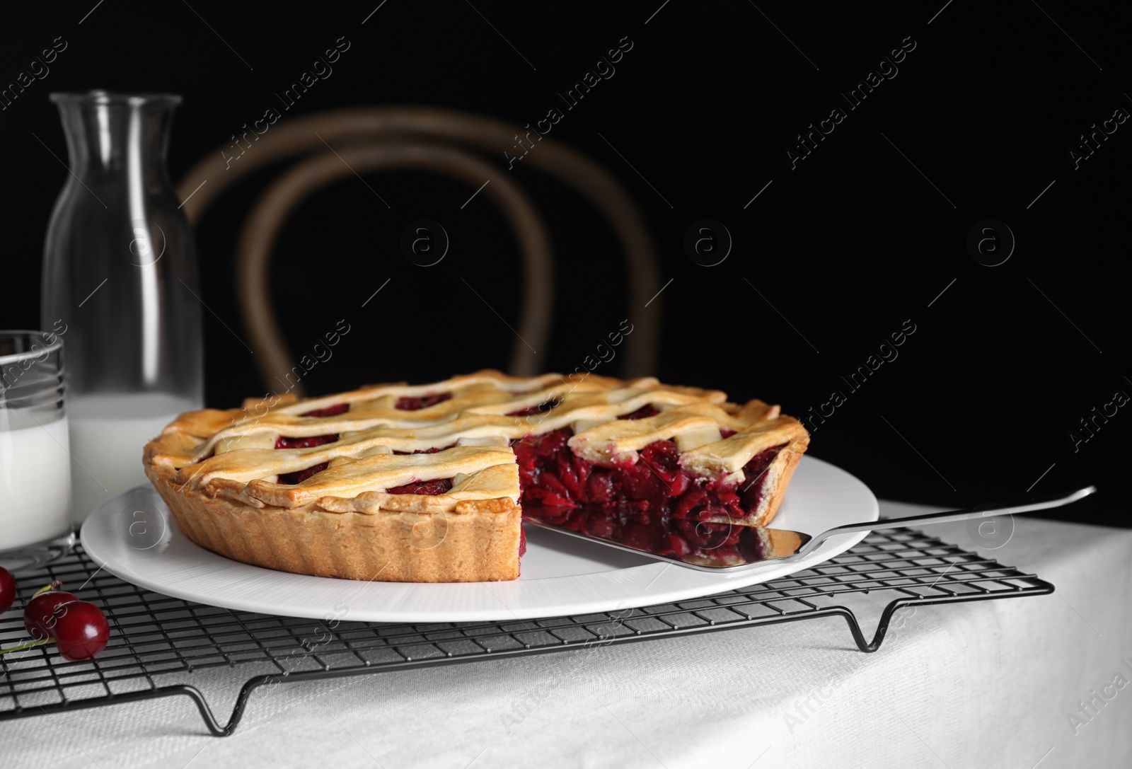 Photo of Delicious fresh cherry pie on table against dark background