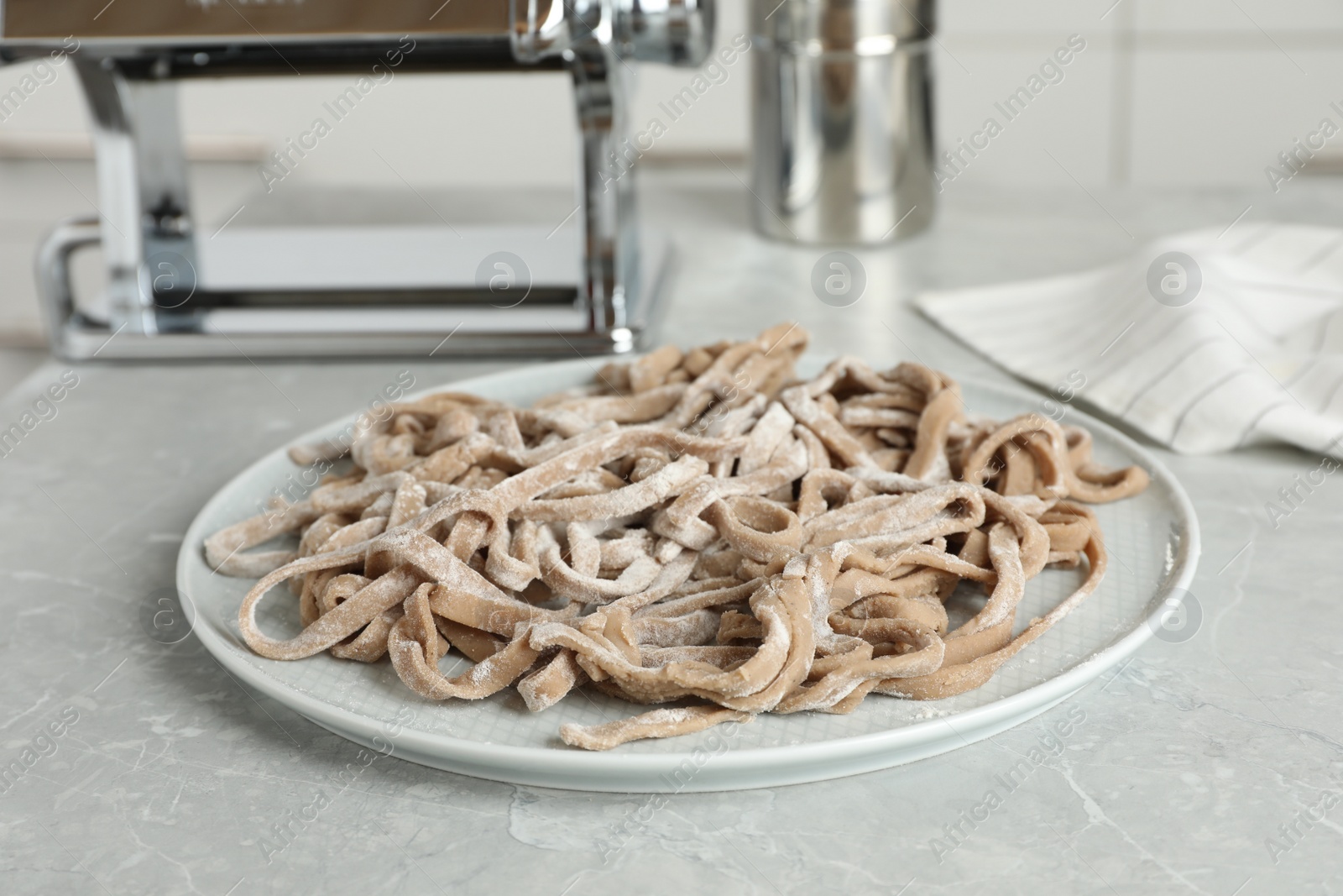 Photo of Uncooked homemade soba (buckwheat noodles) on grey table in kitchen