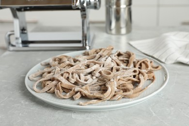 Photo of Uncooked homemade soba (buckwheat noodles) on grey table in kitchen