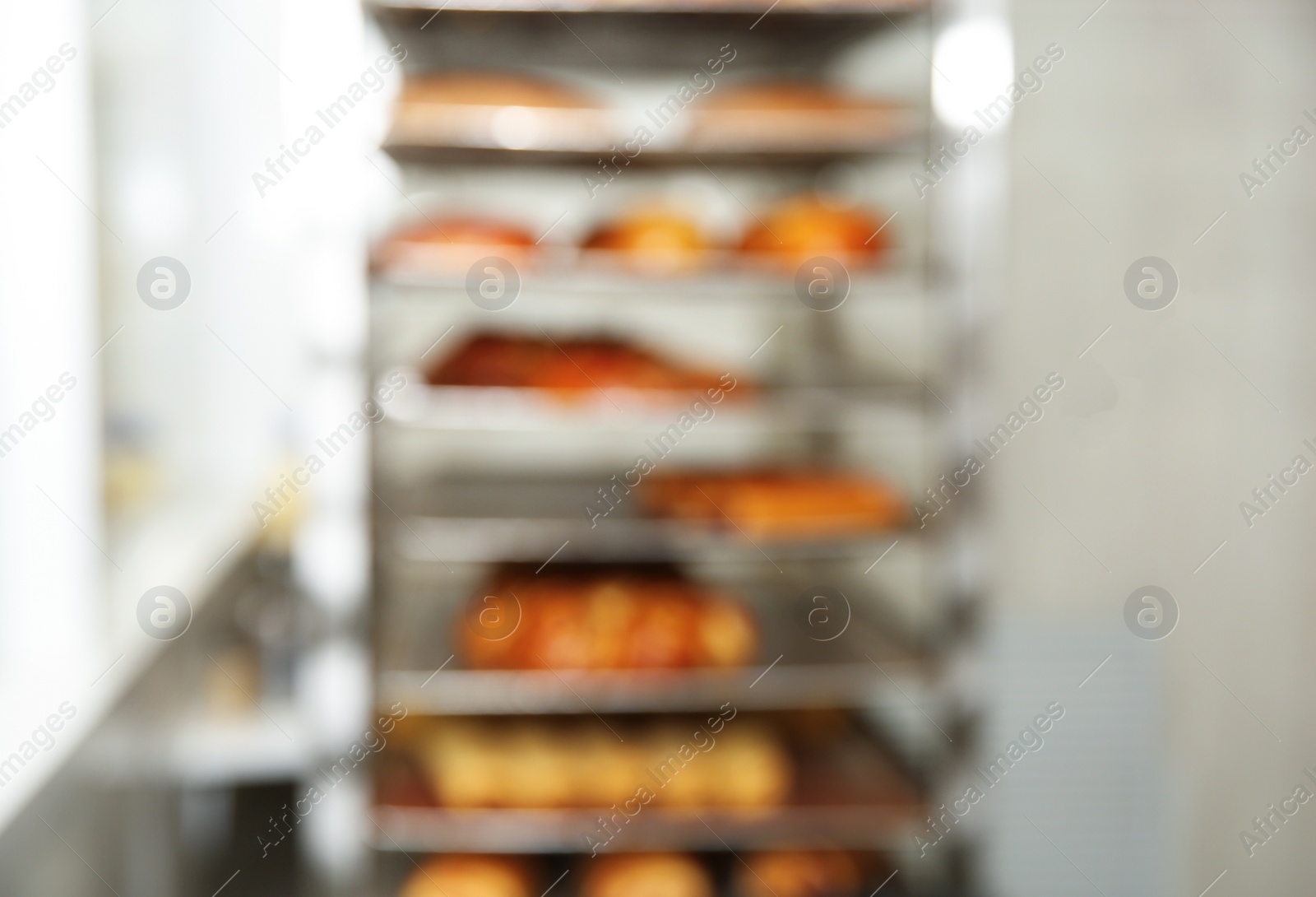 Photo of Blurred view of rack with pastries in bakery workshop