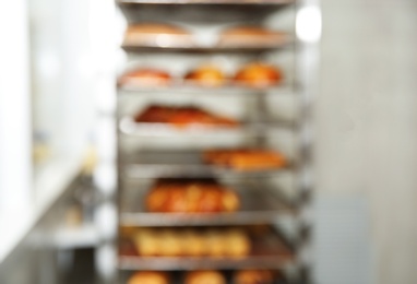 Photo of Blurred view of rack with pastries in bakery workshop