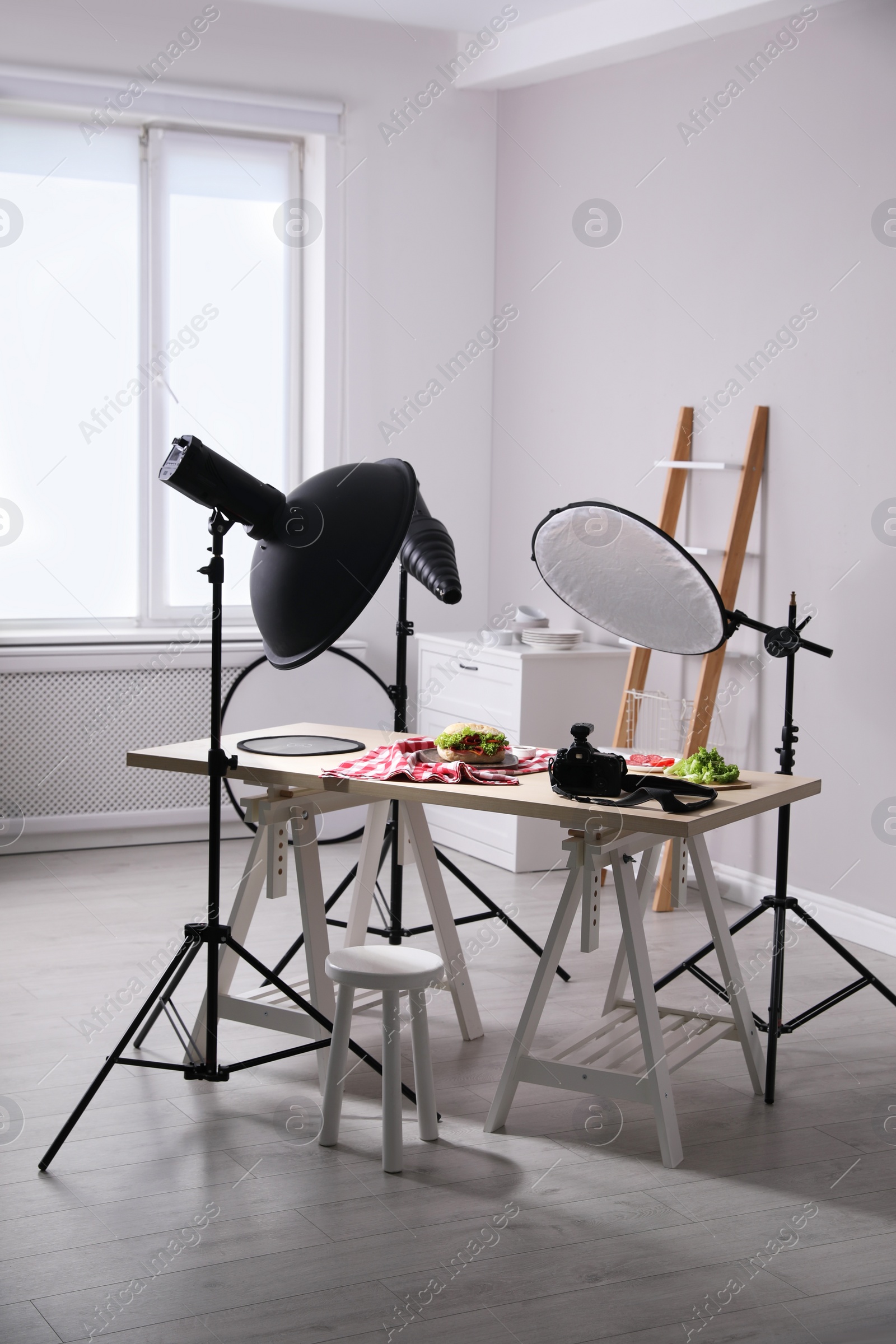 Photo of Professional camera and composition with tasty sandwich on table in photo studio. Food photography
