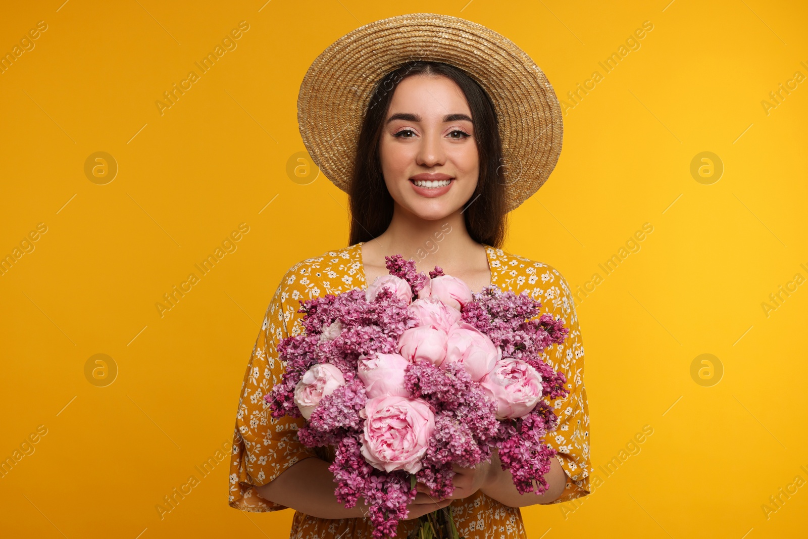 Photo of Beautiful woman with bouquet of spring flowers on yellow background