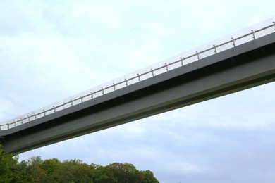 Photo of Beautiful pedestrian bridge against cloudy sky, low angle view