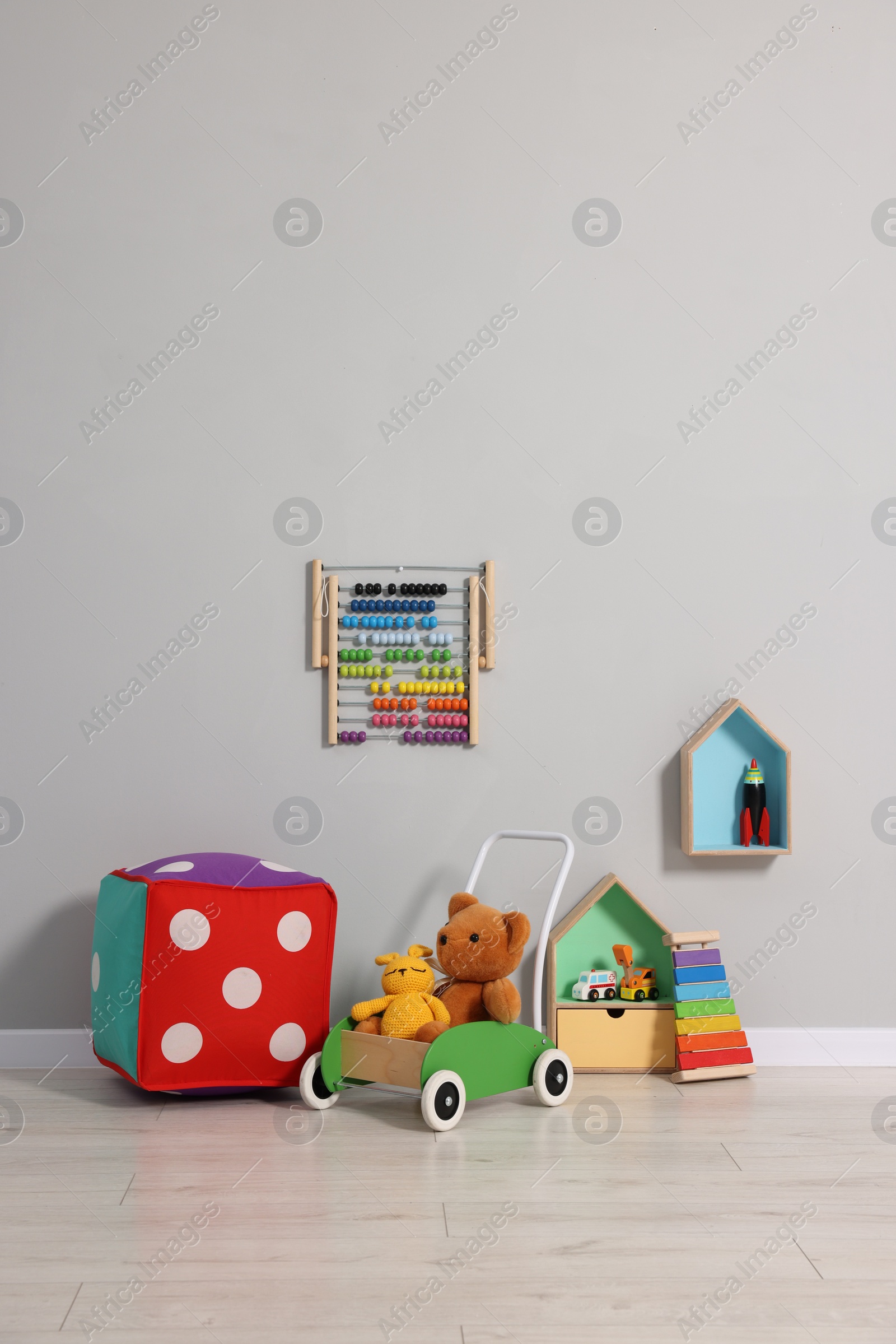 Photo of Beautiful children's room with grey wall and toys. Interior design