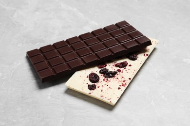 Different chocolate bars with freeze dried grapes on light marble table