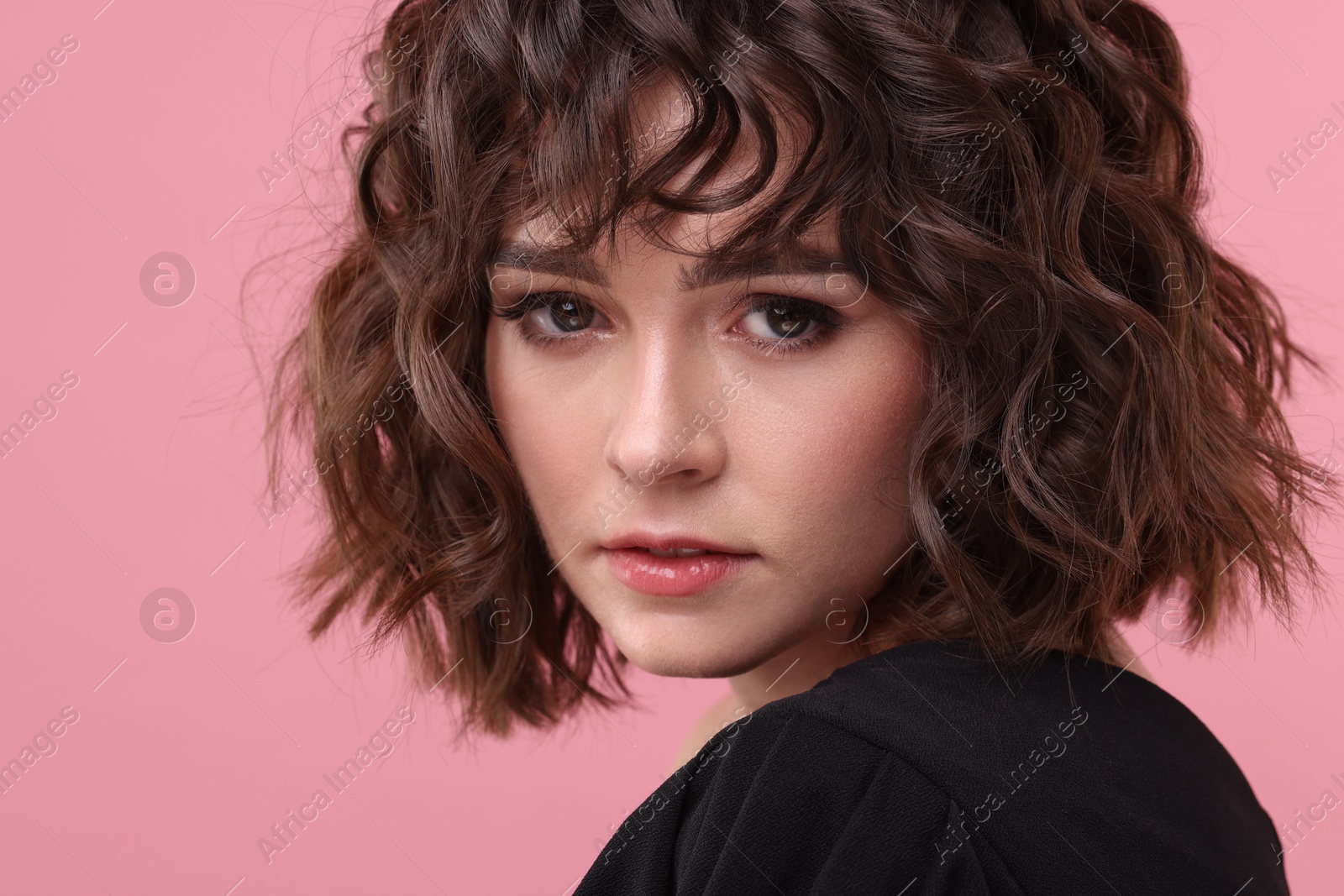 Photo of Beautiful young woman with wavy hairstyle on pink background