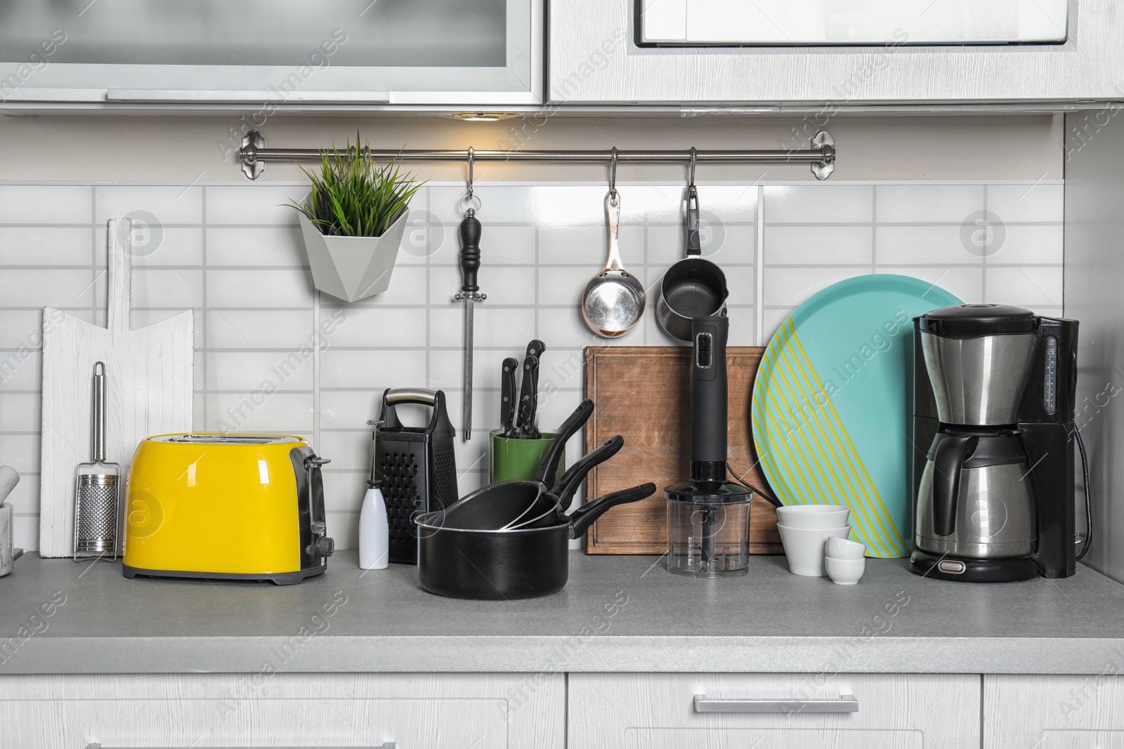 Photo of Set of cookware, clean dishes and appliances on kitchen counter