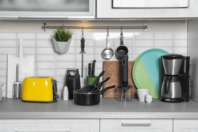 Photo of Set of cookware, clean dishes and appliances on kitchen counter